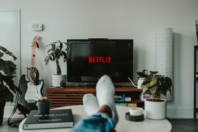 Person with Feet on Coffee Table Watching Netflix on Screen